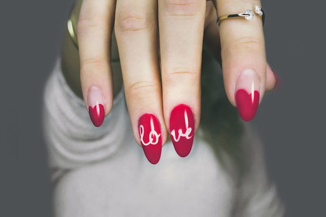 Hand-painted 'love' calligraphy on red stiletto handmade fake nails
