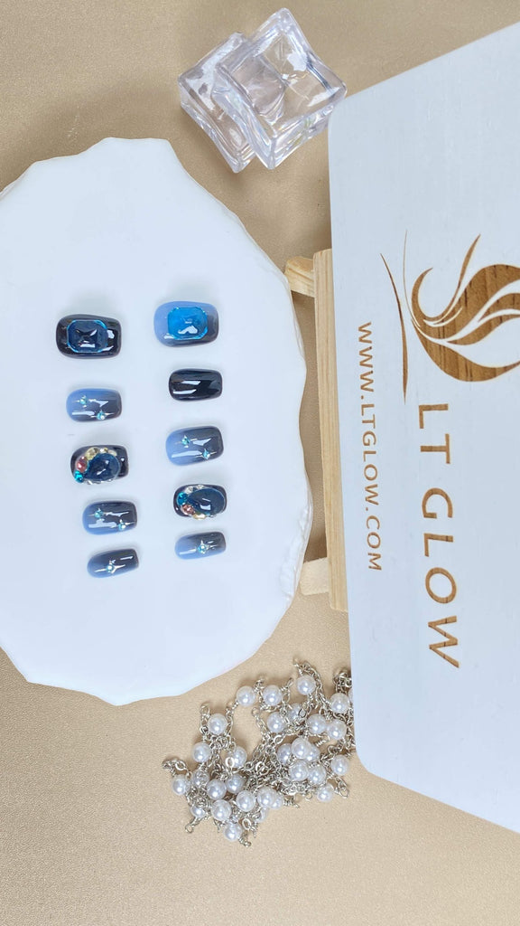 Elevate your style with our black-blue squoval acrylics nails design, intricately hand-painted with stars and accentuated with diamond and crystal embellishments