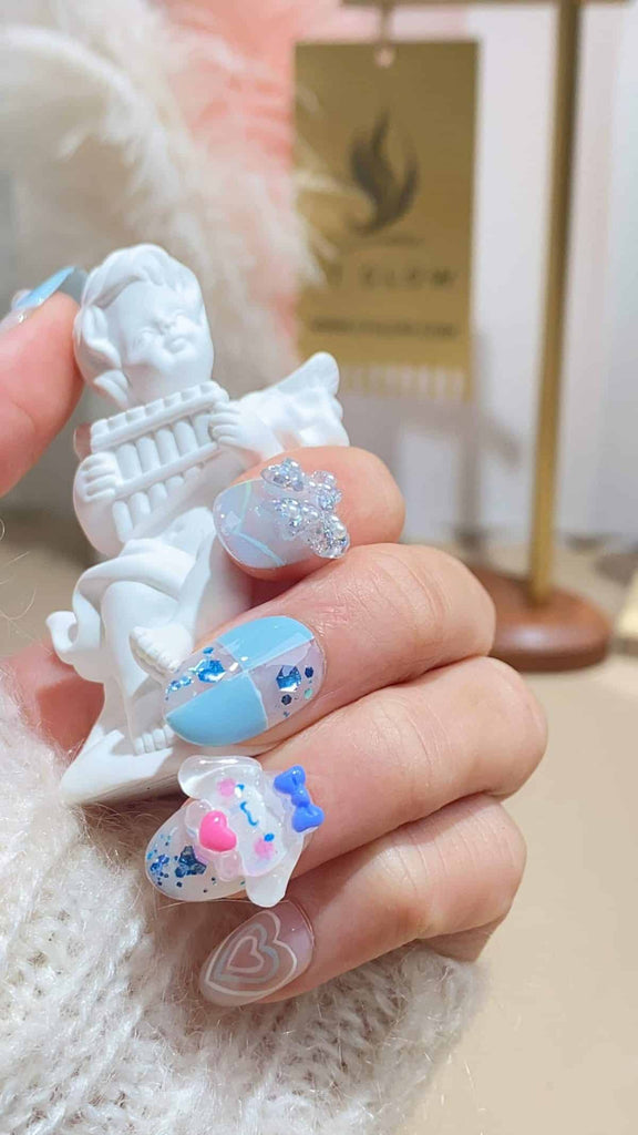 Playful squoval press-on nails by LT-Glow featuring a gradient of blue, pink, and white, adorned with pearl and cartoon-inspired glitter accents