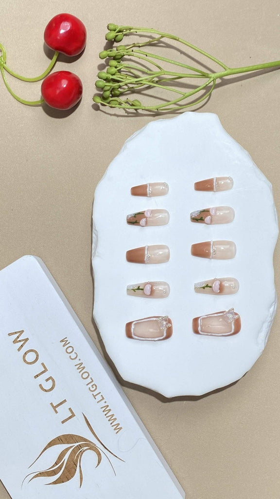 Coffin-styled fake nails from LTGlow, decorated with a harmonious mix of brown and nude, enhanced with rhombus designs, diamonds, and delicate flowers