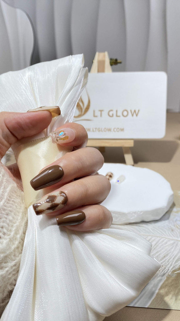 LTGlow's handmade press-on nails in a coffin shape, featuring brown nude shades with rhombus patterns and glitter charm accents