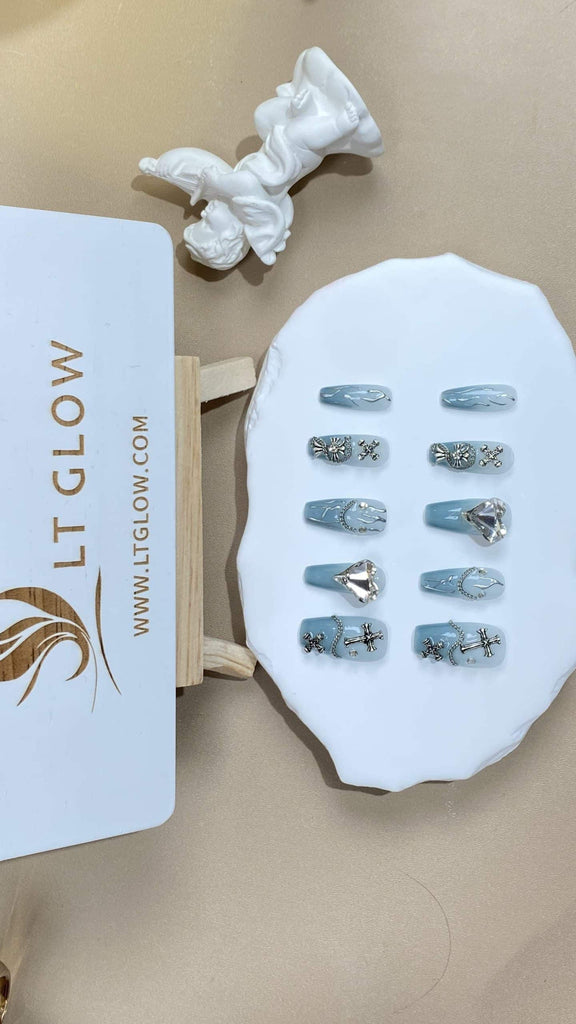 Showcase the essence of acrylics nails design with our coffin-shaped false nails, transitioning smoothly through shades of blue and accented with dainty heart charms