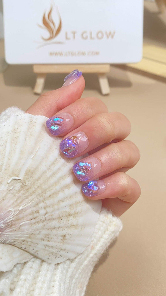 Handcrafted round press-on nails by LTGlow, showcasing a gradient purple design embellished with crystals and sparkling glitter