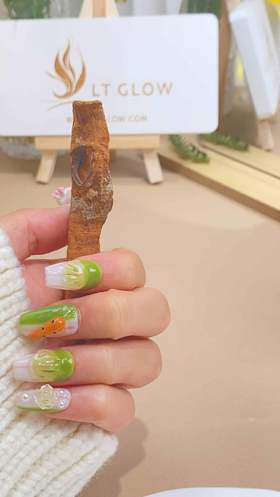 Handcrafted coffin press-on nails by LTGlow, showcasing a gradient green design adorned with rose motifs, playful carrot and rabbit embellishments
