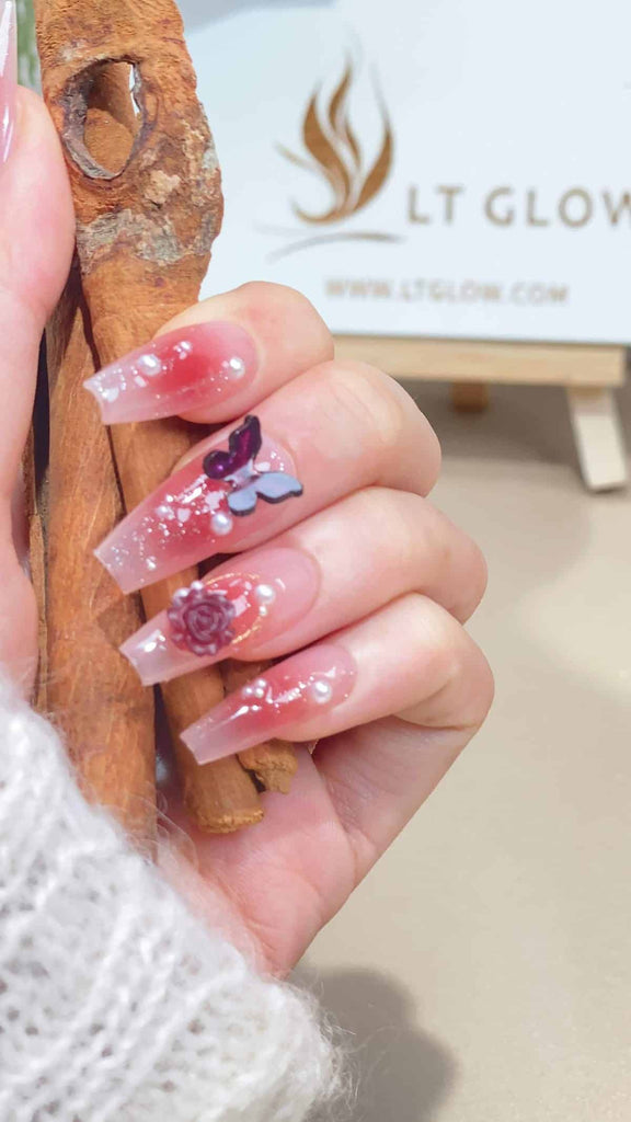 Elegant gradient pink press on nails adorned with rose, pear flower, and butterfly motifs, hand-painted in a coffin shape for a sophisticated acrylic nails design look