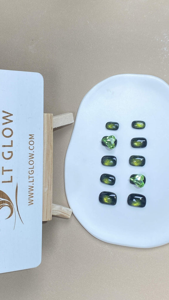 Round-styled fake nails from LT-Glow, presenting a rich green hue inspired by mesmerizing cat eyes, enhanced with glittery undertones and elegant diamond adornments