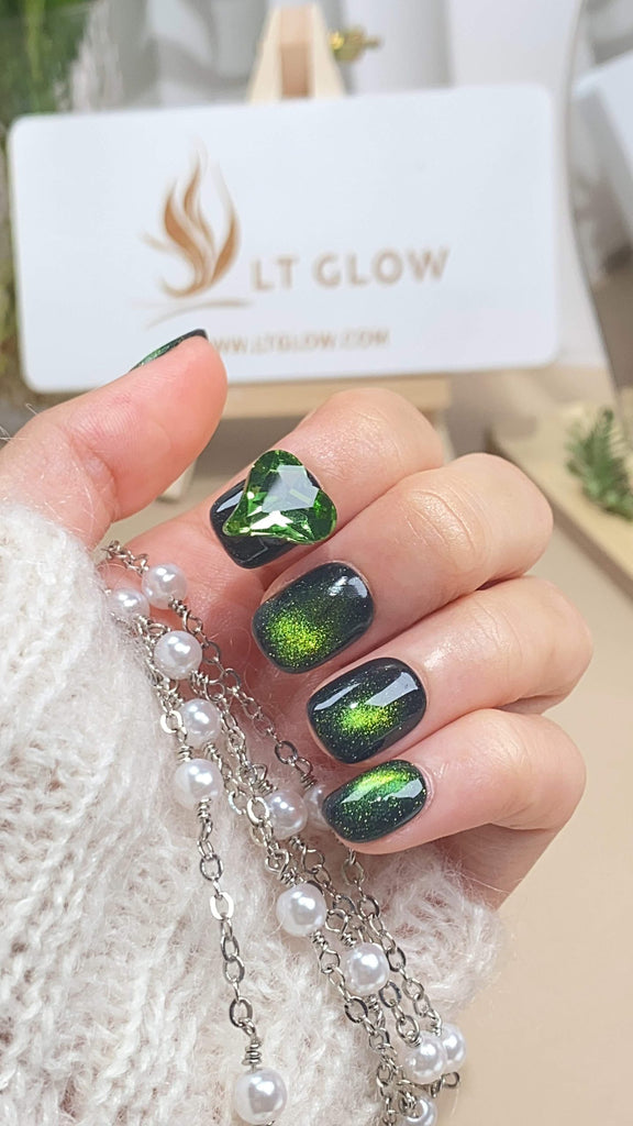 Handcrafted round press-on nails by LT-Glow, infused with a mystic green cat-eye effect, complemented by glimmering glitter and dazzling diamond details