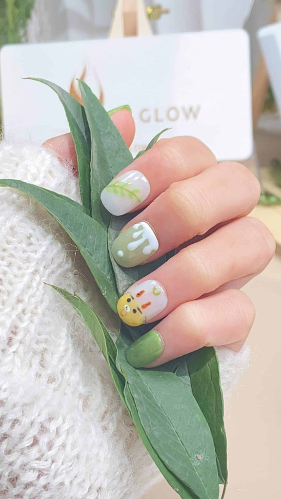 Handmade squoval press-on nails by LTGlow, showcasing a harmonious blend of green and white, adorned with intricate cattle motifs and delicate leaf patterns