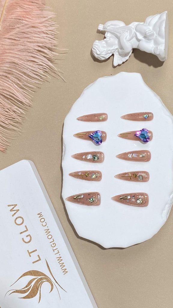 Stiletto-styled fake nails from LTGlow, showcasing a chic nude base, complemented by sparkling glitter, intricate charms, and shimmering diamonds