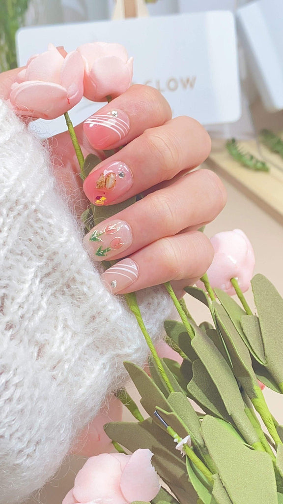 Handmade squoval press-on nails by LTGlow, showcasing a delicate pink design adorned with tulip motifs and shimmering diamond embellishments