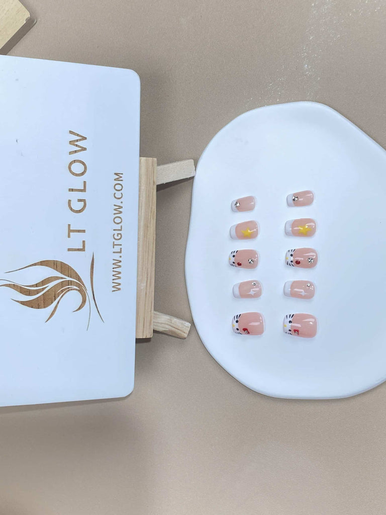 Squoval-styled fake nails from LTGlow, showcasing a chic interplay of pink and white, adorned with radiant diamonds and a subtle cat motif