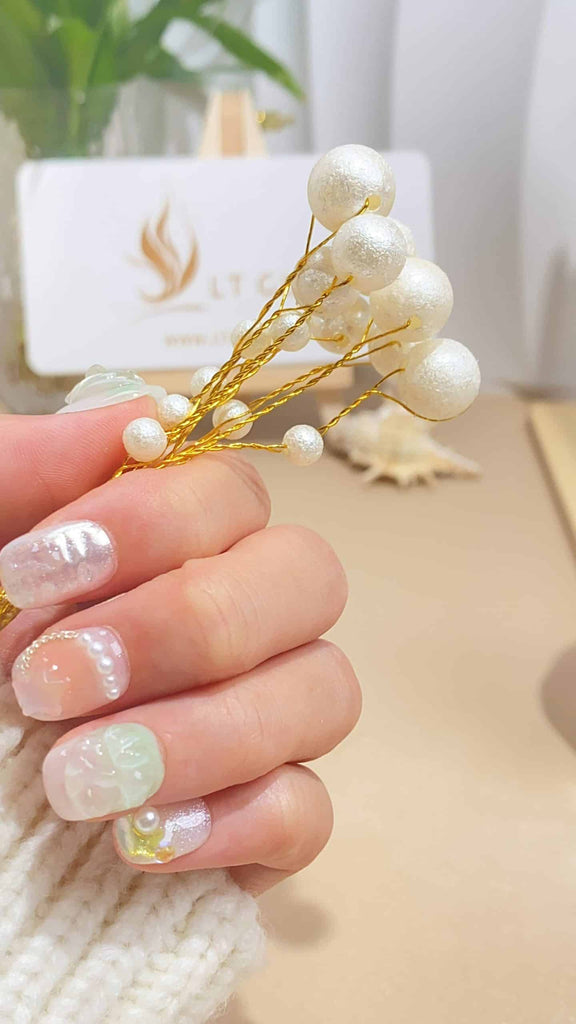 Delight in our round-shaped press-on nails, artistically hand-painted with delicate tulips on a pure white backdrop, complemented by the glow of elegant pearls