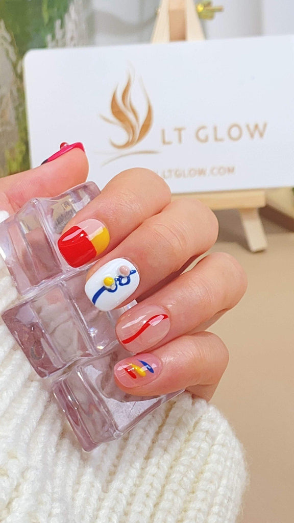 Handmade round press-on nails by LTGlow, featuring a playful blend of white and red adorned with cartoon-inspired charms