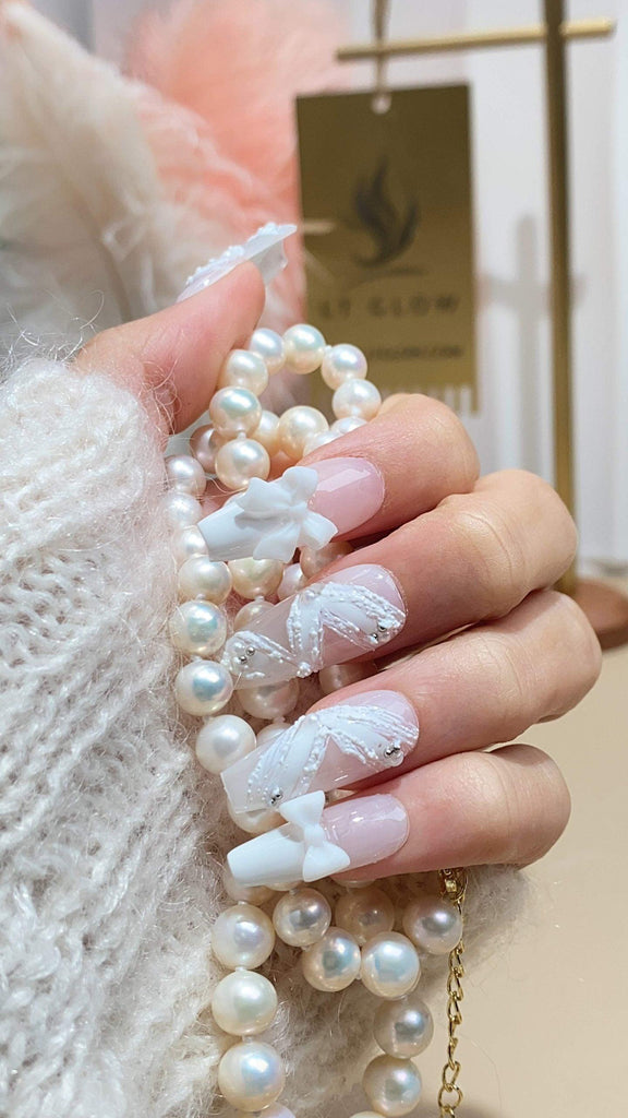 Handcrafted coffin press-on nails by LTGlow, showcasing a pristine white design adorned with delicate bows and pearlet accents