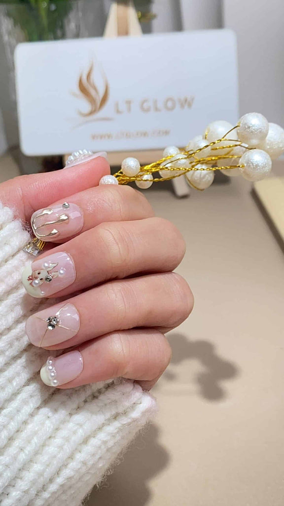 Handmade squoval press-on nails by LT-Glow, displaying a pristine white base, adorned with shimmering diamond embellishments, delicate rabbit motifs, and lustrous pearls