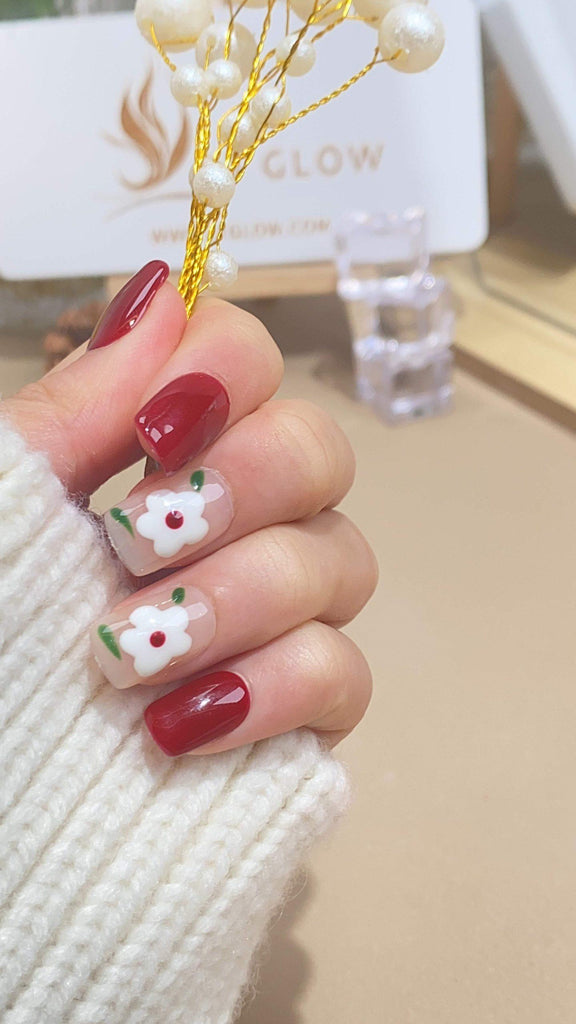 Handcrafted press-on nails by LTGlow in a square shape, featuring delicate white flower designs on a blend of red and nude backgrounds
