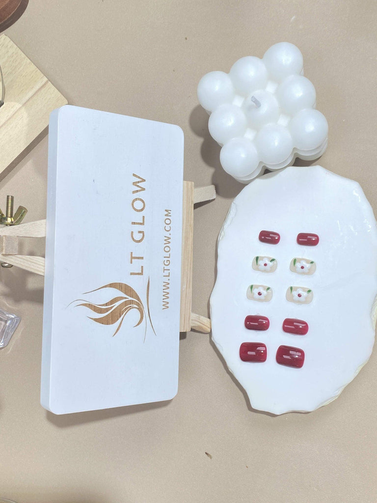 Square-styled fake nails from LTGlow, showcasing intricate white flower motifs contrasted against vibrant red and subtle nude hues