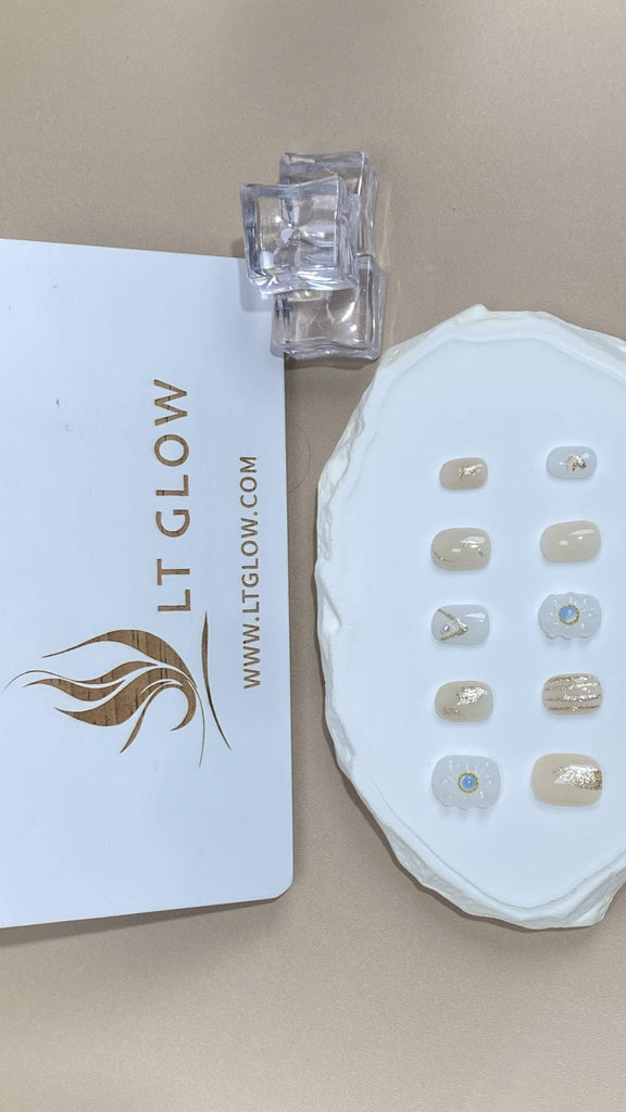 Round-styled fake nails from LTGlow, showcasing a pure white base, enhanced by intricate flower designs, radiant diamonds, and glittery highlights