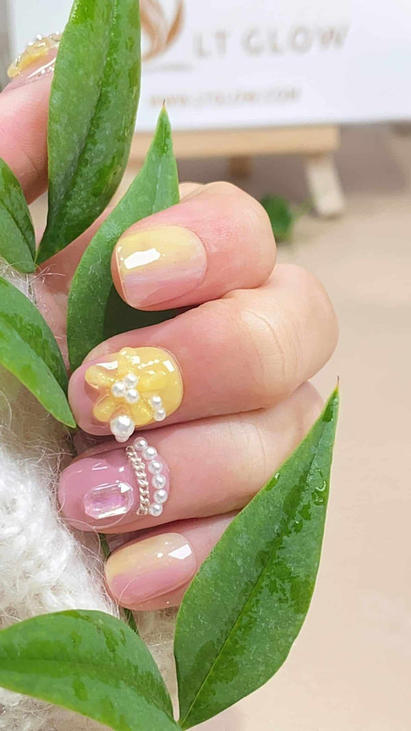 Immerse yourself in the enchantment of these yellow and pink round press on nails, meticulously hand-painted with floral designs, and adorned with 3D charms and pearls. An exquisite example of acrylic nails design artistry