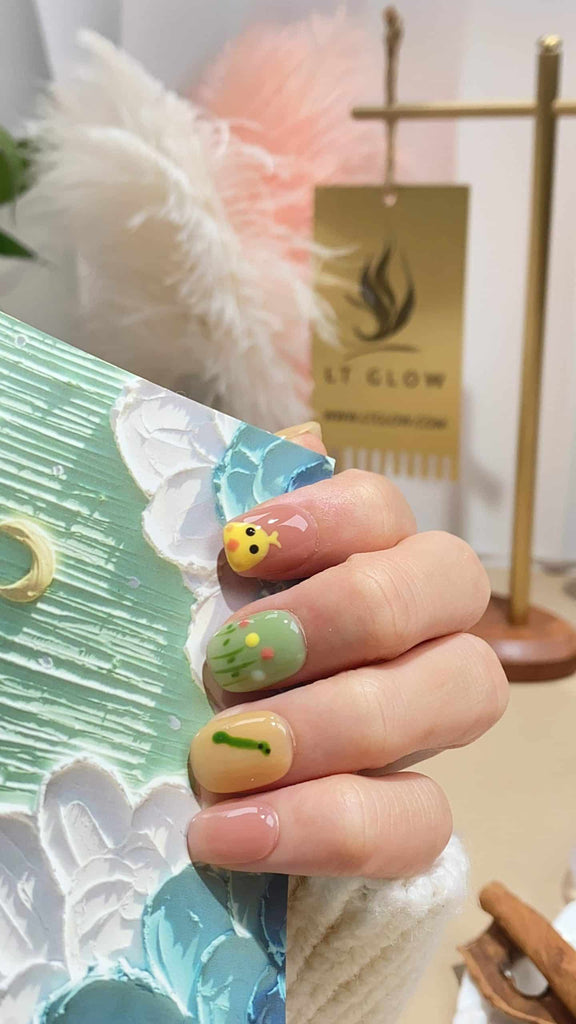 Handmade squoval press-on nails by LTGlow, showcasing a delightful blend of yellow and green, adorned with charming chicken motifs and blooming flower patterns