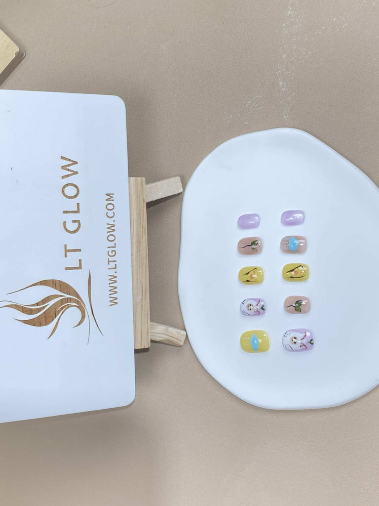 Squoval-styled fake nails from LTGlow, showcasing a whimsical mix of yellow and purple hues, enhanced by endearing sheep figures and cloud-inspired accents