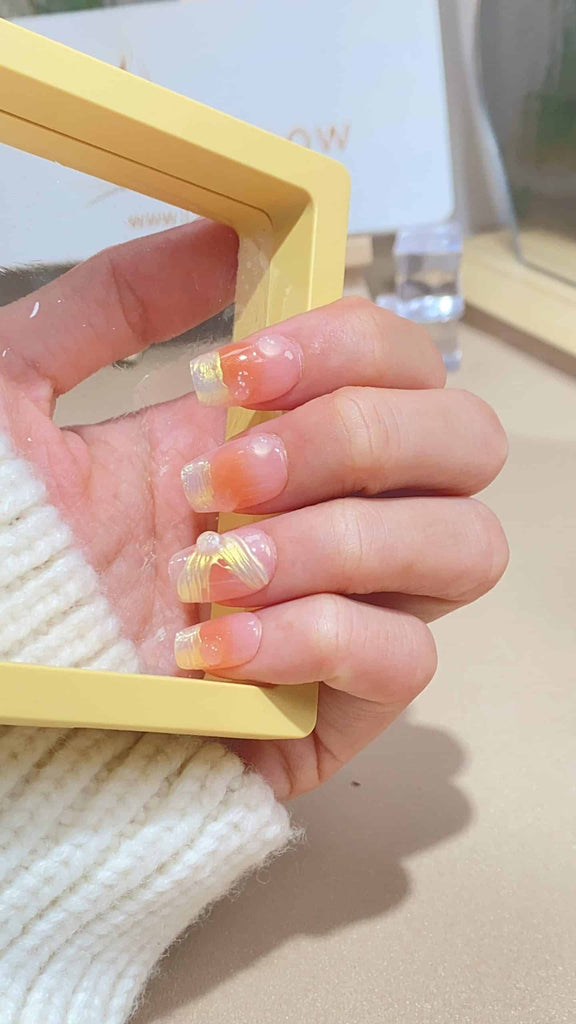 Elegant coffin-shaped press-on nails by LT-Glow, beautifully transitioning from pink to yellow, adorned with crystals and a hint of glitter