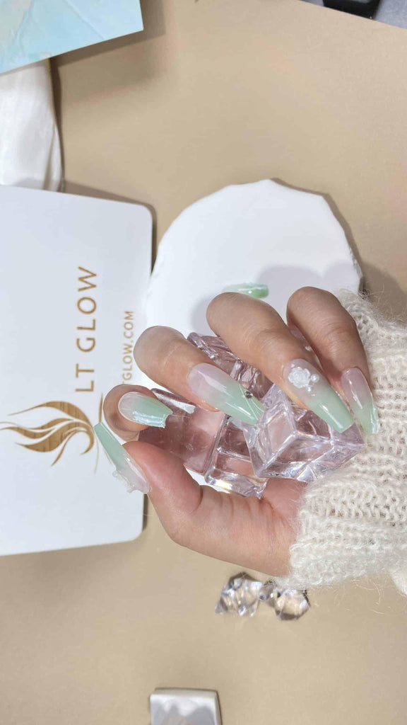 Handmade press-on nails by LTGlow in a coffin shape, featuring a gradient green design with rose, pearl, and moon motifs