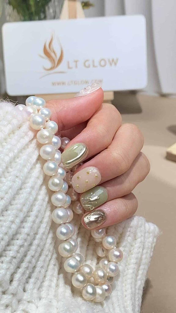 Exquisite squoval nails by LT-Glow, radiating elegance with a pristine white base. Accented with shimmering gold, delicate pearls, and intricate 3D charms, each nail is a hand-painted work of art, epitomizing sophistication and craftsmanship