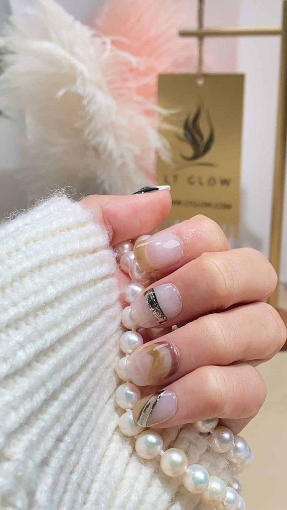 Elegant squoval press-on nails by LT-Glow, blending white, nude, and brown tones, enhanced with delicate charms