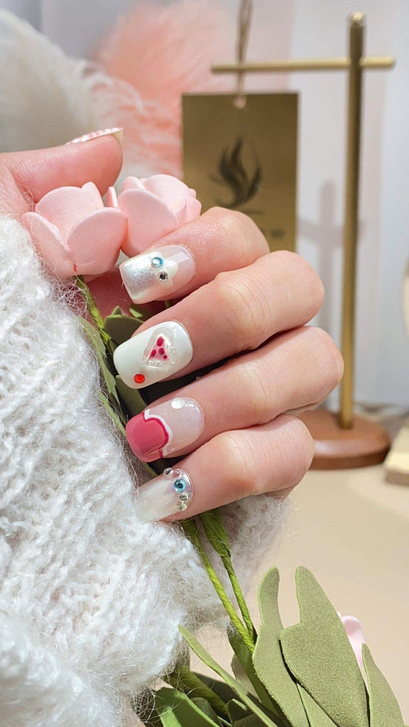 Elegant squoval press-on nails by LT-Glow, showcasing a soft transition from white to pink, highlighted with diamond and heart accents