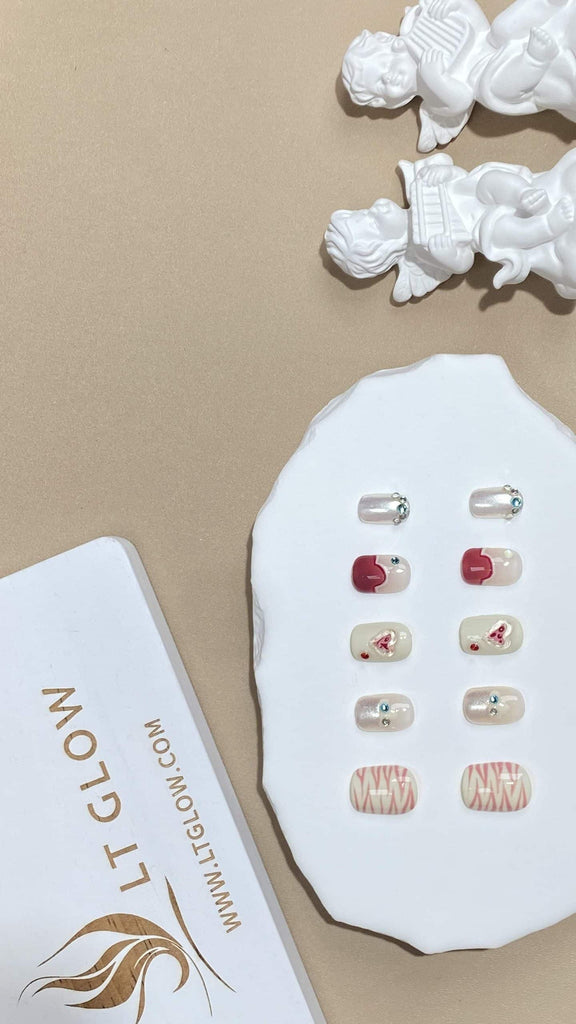 Handcrafted by LT-Glow, these squoval fake nails feature a beautiful gradient from white to pink, adorned with shimmering diamonds and heart designs