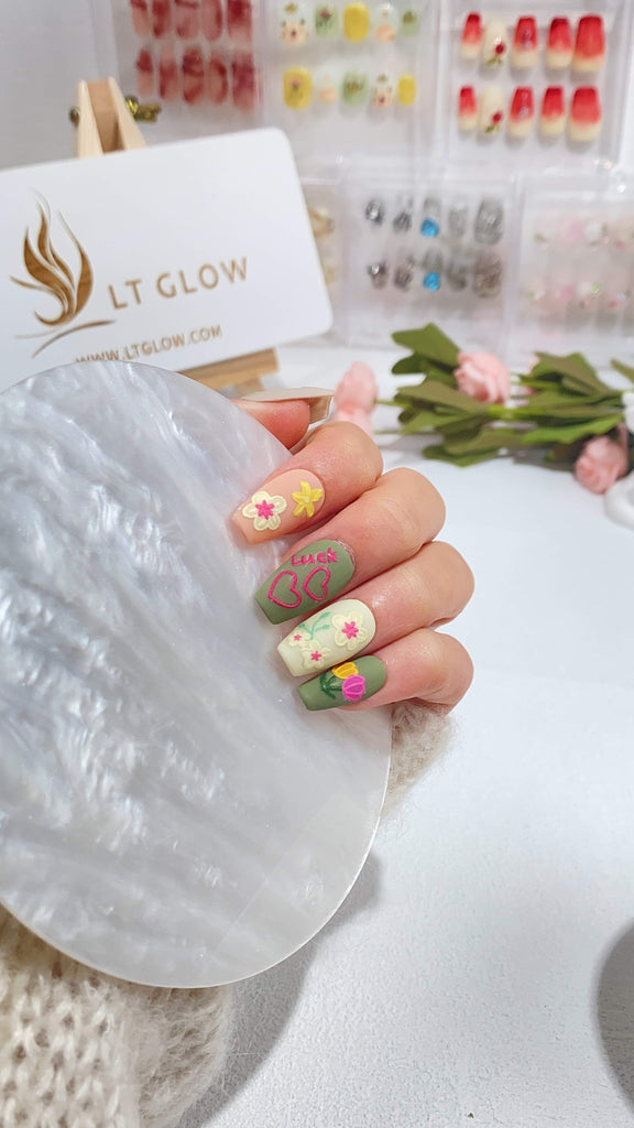 LT Glow's hand-painted coffin-shaped press-on nails featuring gray, pink, green, and white hues with delicate flower and angel designs
