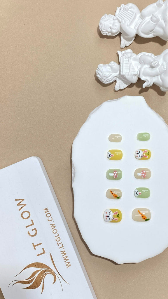 Elegant false nails by LTGlow in a squoval shape, capturing the playful essence of green and yellow, decorated with cute rabbit motifs and carrot embellishments