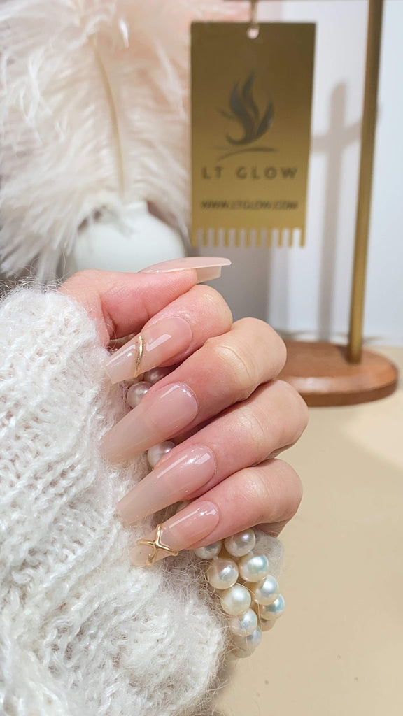 LT Glow's handcrafted coffin-shaped press-on nails in a delicate nude, enhanced with 3D elements and unique charms