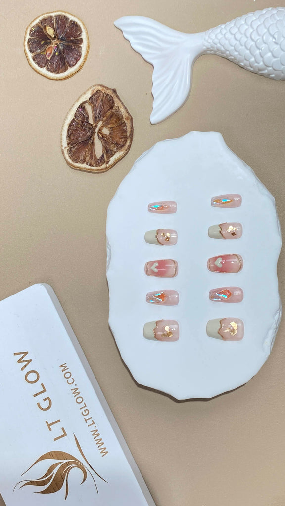  Handcrafted false nails from LT Glow, exuding romance with pink hues, heart charms, hand-painted French design, and glitter in a coffin shape