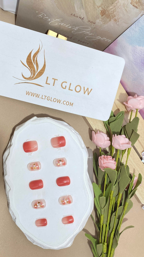 LT Glow's squoval-shaped press-on nails in a charming blend of pink and nude, featuring glitter accents for a touch of sparkle and style.