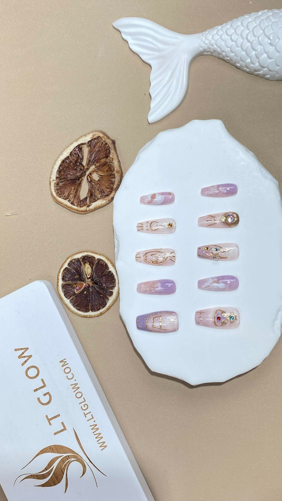 Handmade false nails from LT Glow, uniquely designed with zodiac motifs hand-painted in purple and white on a coffin silhouette