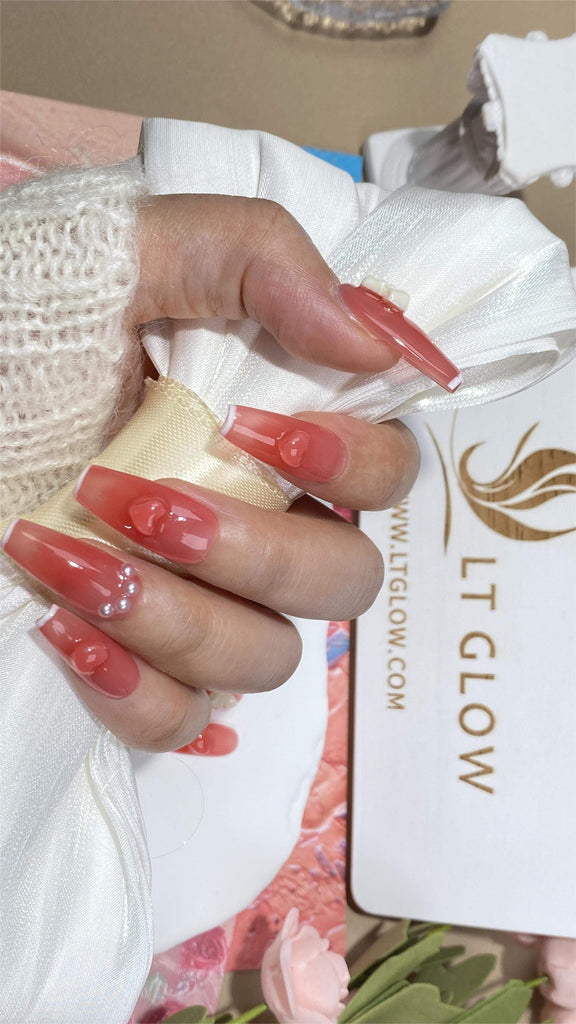 LT Glow's Pink Coffin Nails featuring 3D embellishments and elegant charms, intricately paired with pearls for a luxurious finish