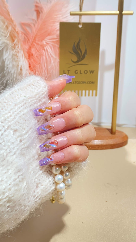 Elegant purple coffin nails adorned with sparkling crystals and glitter detailing